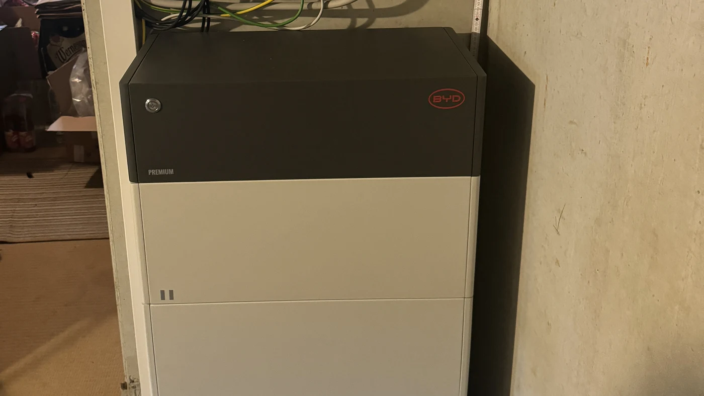 BYD-Hausspeicher "Premium" mit Herstelleraufschrift, Schloss und zwei sichtbaren Batteriemodulen, an einer Kellerwand montiert