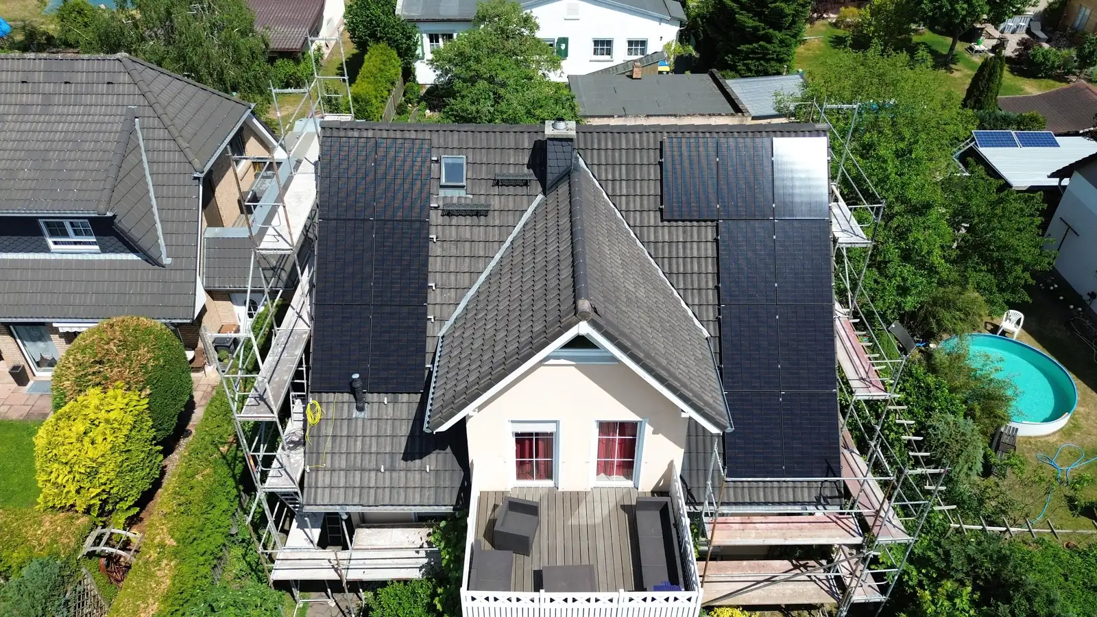 Luftaufnahme einer Photovoltaikanlage mit Jinko Solar-Modulen auf einem Hausdach