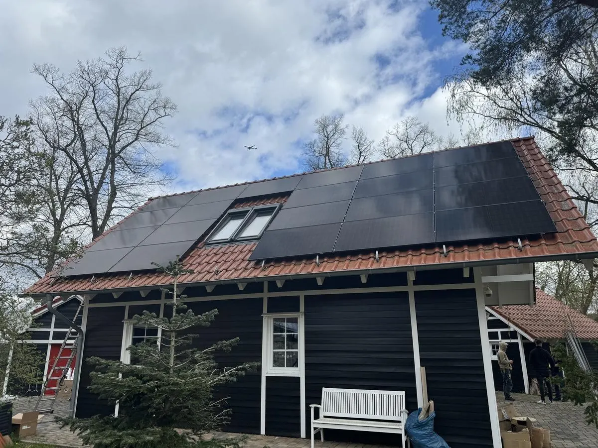 Luftaufnahme einer Photovoltaikanlage mit Jinko Solar-Modulen auf einem Hausdach
