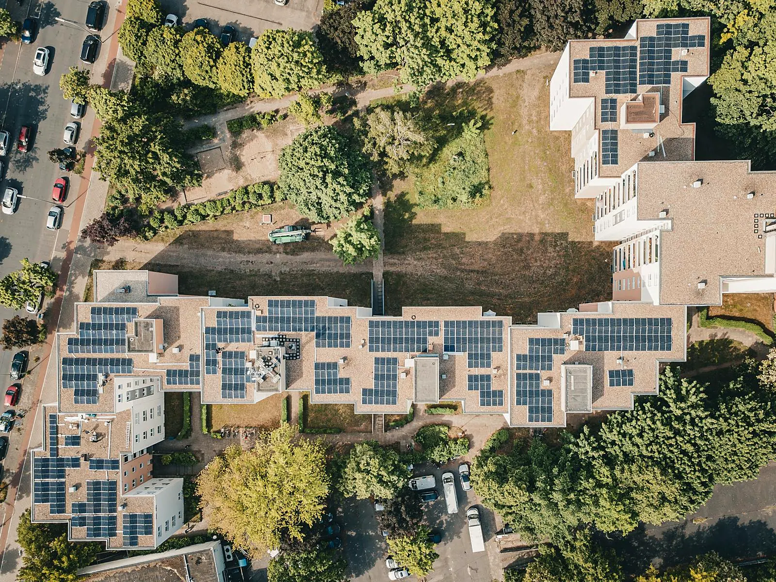 Flachdachanlage über mehrere Gebäudeteile eines Mehrfamilienhaus-Komplexes hinweg.
